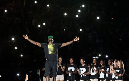 LeBron James acknowledges the crowd's reaction as he takes the stage for the I PROMISE Family Reunion event to welcome him home