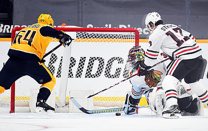 Jan 26, 2021; Nashville, Tennessee, USA; Chicago Blackhawks goaltender Malcolm Subban (30) covers a puck in the crease against  Nashville Predators center Mikael Granlund (64) during the second period at Bridgestone Arena. Mandatory Credit: Christopher Hanewinckel-USA TODAY Sports