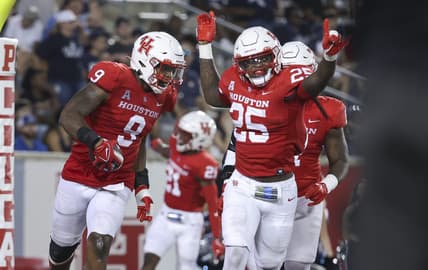 Sep 24, 2022; Houston, Texas, USA; Houston Cougars defensive lineman Nelson Ceaser (9) celebrates with linebacker Jamal Morris (25) after returning a fumbled ball for a touchdown during the fourth quarter against the Rice Owls at TDECU Stadium. Mandatory Credit: Troy Taormina-USA TODAY Sports