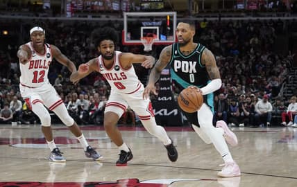 Feb 4, 2023; Chicago, Illinois, USA; Portland Trail Blazers guard Damian Lillard (0) drives to the basket against Chicago Bulls guard Coby White (0) and guard Ayo Dosunmu (12) during the second half at United Center. Mandatory Credit: David Banks-USA TODAY Sports