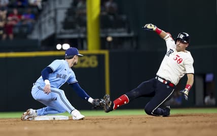 Jun 16, 2023; Arlington, Texas, USA;  Toronto Blue Jays second baseman Cavan Biggio (8) tags out Texas Rangers first baseman Nathaniel Lowe (30) at second base during the eighth inning at Globe Life Field. Mandatory Credit: Kevin Jairaj-USA TODAY Sports