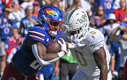 Oct 7, 2023; Lawrence, Kansas, USA;  Kansas Jayhawks running back Daniel Hishaw Jr. (20) runs up field against UCF Knights linebacker Jason Johnson (0) during the first half at David Booth Kansas Memorial Stadium. Mandatory Credit: Peter Aiken-USA TODAY Sports