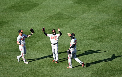 Apr 4, 2021; Boston, Massachusetts, USA;  Baltimore Orioles left fielder Pat Valaika (11) center fielder Cedric Mullins (31) and right fielder Anthony Santander (25) react after defeating the Boston Red Sox at Fenway Park. Mandatory Credit: Bob DeChiara-USA TODAY Sports