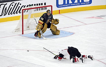 Apr 11, 2021; Las Vegas, NV, USA; Arizona Coyotes right wing Clayton Keller (9) slips on the ice as Vegas Golden Knights goaltender Marc-Andre Fleury (29) defends during the second period at T-Mobile Arena. (Mandatory Credit: David Beckeri-USA TODAY Sports via The Associated Press)