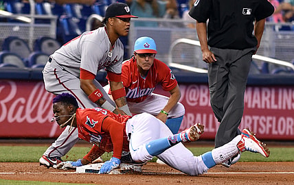 Jun 26, 2021; Miami, Florida, USA; Miami Marlins second baseman Jazz Chisholm Jr. (2) dives into third base as Washington Nationals third baseman Starlin Castro (13) looks on during the first inning at loanDepot Park. Mandatory Credit: Jim Rassol-USA TODAY Sports