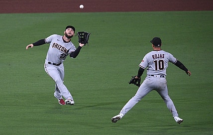 Apr 2, 2021; San Diego, California, USA; Arizona Diamondbacks left fielder Wyatt Mathisen (27) catches a fly ball hit by San Diego Padres catcher Luis Campusano (not pictured) as shortstop Josh Rojas (10) looks on during the second inning at Petco Park. Mandatory Credit: Orlando Ramirez-USA TODAY Sports