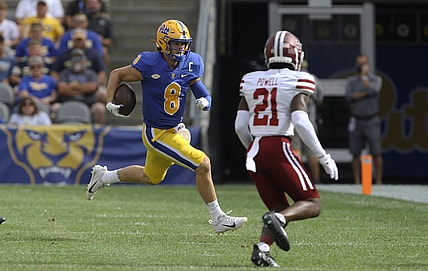 Sep 4, 2021; Pittsburgh, Pennsylvania, USA;  Pittsburgh Panthers quarterback Kenny Pickett (8) carries the ball against Massachusetts Minutemen defensive back Te'Rai Powell (21) during the first quarter at Heinz Field. Mandatory Credit: Charles LeClaire-USA TODAY Sports