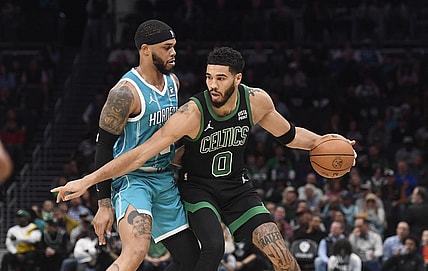 Nov 20, 2023; Charlotte, North Carolina, USA; Boston Celtics forward Jayson Tatum (0) looks to drive past Charlotte Hornets forward Miles Bridges (0) during the first half at the Spectrum Center. Mandatory Credit: Sam Sharpe-USA TODAY Sports