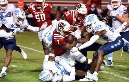 Nov 26, 2021; Raleigh, North Carolina, USA;  North Carolina State Wolfpack running back Zonovan Knight (7) is tackled after a run by North Carolina Tar Heels linebacker Cedric Gray (33) during the first half at Carter-Finley Stadium. Mandatory Credit: Rob Kinnan-USA TODAY Sports