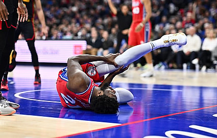 Dec 8, 2023; Philadelphia, Pennsylvania, USA; Philadelphia 76ers center Joel Embiid (21) grabs his knee after falling against the Atlanta Hawks in the fourth quarter at Wells Fargo Center. Mandatory Credit: Kyle Ross-USA TODAY Sports
