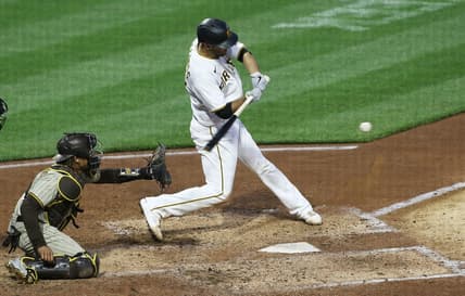 Apr 13, 2021; Pittsburgh, Pennsylvania, USA; Pittsburgh Pirates catcher Jacob Stallings (R) hits an RBI single against the San Diego Padres during the second inning at PNC Park. Mandatory Credit: Charles LeClaire-USA TODAY Sports