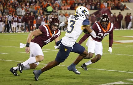 Sep 22, 2022; Blacksburg, Virginia, USA; West Virginia Mountaineers wide receiver Kaden Prather (3) runs the ball between Virginia Tech Hokies linebacker Dax Hollifield (4) and defensive back Chamarri Conner (25) at Lane Stadium. Mandatory Credit: Reinhold Matay-USA TODAY Sports