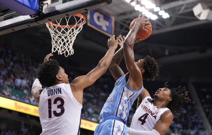 Mar 9, 2023; Greensboro, NC, USA; North Carolina Tar Heels forward Leaky Black (1) shoots as Virginia Cavaliers guard Ryan Dunn (13) and guard Armaan Franklin (4) defend in the first half of the quarterfinals of the ACC tournament at Greensboro Coliseum.  Mandatory Credit: Bob Donnan-USA TODAY Sports