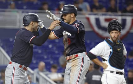 Apr 3, 2023; Miami, Florida, USA;  Miami Marlins catcher Jacob Stallings (58) watches Minnesota Twins left fielder Trevor Larnach (9) and shortstop Carlos Correa celebrate (4) after a two-run home run during the seventh inning at loanDepot Park. Mandatory Credit: Rhona Wise-USA TODAY Sports