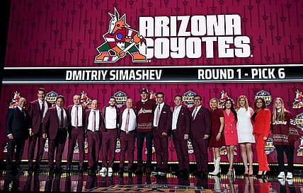 Jun 28, 2023; Nashville, Tennessee, USA; Arizona Coyotes draft pick Dmitriy Simashev stands with Coyotes staff after being selected with the sixth pick in round one of the 2023 NHL Draft at Bridgestone Arena. Mandatory Credit: Christopher Hanewinckel-USA TODAY Sports