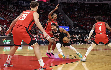 Dec 13, 2023; Houston, Texas, USA; Memphis Grizzlies guard Derrick Rose (23) splits the defense of Houston Rockets forward Jabari Smith Jr. (10) and Hguard Jalen Green (4) and against  center Alperen Sengun (28)  in the first quarter at Toyota Center. Mandatory Credit: Thomas Shea-USA TODAY Sports