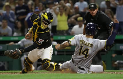 Aug 14, 2021; Pittsburgh, PA, USA; Milwaukee Brewers first baseman Jace Peterson (14) scores past Pittsburgh Pirates catcher Michael Perez (5) from second base after a throwing error by Perez on a pick-off attempt during the sixth inning at PNC Park. Mandatory Credit: Charles LeClaire-USA TODAY Sports