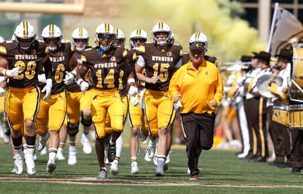 Sep 18, 2021; Laramie, Wyoming, USA; Wyoming Cowboys head coach Craig Bohl leads his team onto the field before game against the Ball State Cardinals at Jonah Field at War Memorial Stadium. Mandatory Credit: Troy Babbitt-USA TODAY Sports