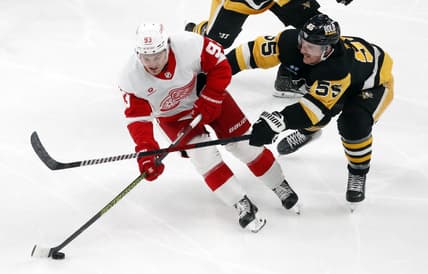 Mar 17, 2024; Pittsburgh, Pennsylvania, USA;  Detroit Red Wings right wing Alex DeBrincat (93) skates with he puck against Pittsburgh Penguins center Noel Acciari (55) during the third period at PPG Paints Arena. Pittsburgh won 6-3. Mandatory Credit: Charles LeClaire-USA TODAY Sports