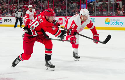 Mar 28, 2024; Raleigh, North Carolina, USA;  Carolina Hurricanes center Martin Necas (88) gets the shot past Detroit Red Wings defenseman Ben Chiarot (8) during the second period at PNC Arena. Mandatory Credit: James Guillory-USA TODAY Sports