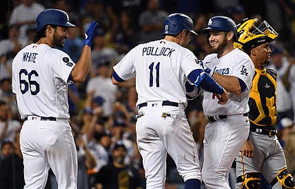 Aug 18, 2021; Los Angeles, California, USA; Los Angeles Dodgers first baseman Max Muncy (second from right) is congratulated by left fielder A.J. Pollock (11) and relief pitcher Mitch White (66) after hitting a three-run home run against the Pittsburgh Pirates during the fourth inning at Dodger Stadium. Mandatory Credit: Richard Mackson-USA TODAY Sports