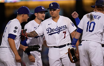 Oct 2, 2021; Los Angeles, California, USA; Los Angeles Dodgers starting pitcher Julio Urias (7) bumps the chest of shortstop Corey Seager (5) as he leaves the game against the Milwaukee Brewers in the seventh inning at Dodger Stadium. Urias left the game with a 7-1 lead as he was going for his Major League leading 20th win of the season. Mandatory Credit: Robert Hanashiro-USA TODAY Sports