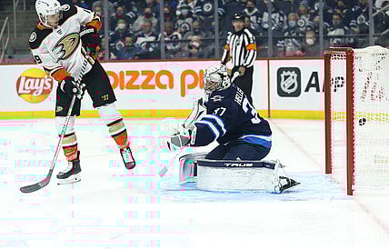 Oct 21, 2021; Winnipeg, Manitoba, CAN;  Anaheim Ducks forward Troy Terry (19) scores on Winnipeg Jets goalie Connor Hellebuyck (37) during the first period at Canada Life Centre. Mandatory Credit: Terrence Lee-USA TODAY Sports