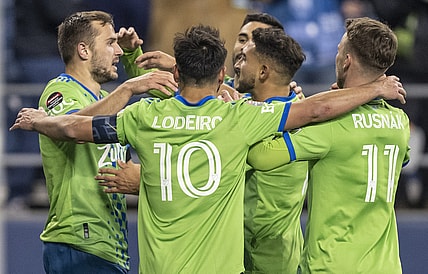 Feb 24, 2022; Seattle, WA, USA; Seattle Sounders FC including, from left, forward Jordan Morris (13), midfielder Nicolas Lodeiro (10), midfielder Cristian Roldan (7)] and midfielder Albert Rusnak (11) celebrate a goal against FC Motagua during the second half at Lumen Field. Mandatory Credit: Stephen Brashear-USA TODAY Sports