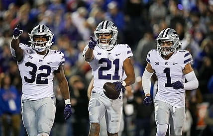 Nov 18, 2023; Lawrence, Kansas, USA; Kansas State Wildcats safety Marques Sigle (21) celebrates with linebacker Desmond Purnell (32) and cornerback Keenan Garber (1) after an interception during the second half against the Kansas Jayhawks at David Booth Kansas Memorial Stadium. Mandatory Credit: Jay Biggerstaff-USA TODAY Sports