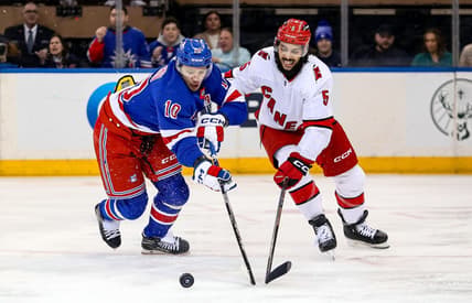 Jan 2, 2024; New York, New York, USA; New York Rangers left wing Artemi Panarin (10) and Carolina Hurricanes defenseman Jalen Chatfield (5) battle for the puck during the first period at Madison Square Garden. Mandatory Credit: Danny Wild-USA TODAY Sports