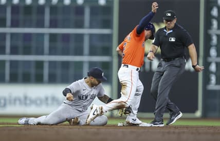Mar 29, 2024; Houston, Texas, USA; Houston Astros third baseman Alex Bregman (2) is safe at second base as New York Yankees second baseman Gleyber Torres (25) attempts to apply a tag during the third inning at Minute Maid Park. Mandatory Credit: Troy Taormina-USA TODAY Sports