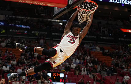 Dec 26, 2021; Miami, Florida, USA; Miami Heat forward Jimmy Butler (22) hangs on the rim after a dunk against the Orlando Magic during the first half at FTX Arena. Mandatory Credit: Jasen Vinlove-USA TODAY Sports