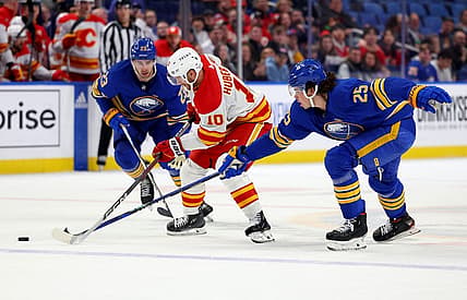 Oct 19, 2023; Buffalo, New York, USA;  Buffalo Sabres defenseman Owen Power (25) knocks the puck off the stick of Calgary Flames center Jonathan Huberdeau (10) during the first period at KeyBank Center. Mandatory Credit: Timothy T. Ludwig-USA TODAY Sports