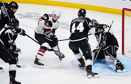 Apr 5, 2021; Los Angeles, California, USA; Arizona Coyotes Michael Bunting (58) pushes the puck past Los Angeles Kings defenseman Mikey Anderson (44) and Los Angeles Kings goaltender Calvin Petersen (40) to score during the first period at Staples Center. Mandatory Credit: Robert Hanashiro-USA TODAY Sports
