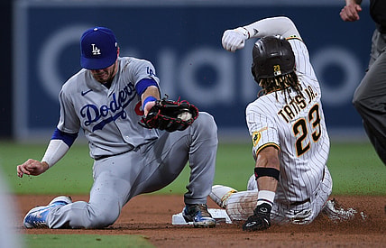 Jun 23, 2021; San Diego, California, USA; San Diego Padres shortstop Fernando Tatis Jr. (23) steals second base ahead of the tag by Los Angeles Dodgers shortstop Gavin Lux (left) during the third inning at Petco Park. Mandatory Credit: Orlando Ramirez-USA TODAY Sports