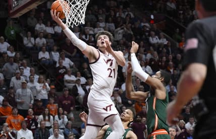 Feb 21, 2023; Blacksburg, Virginia, USA; Virginia Tech Hokies forward Grant Basile (21) drives to basket past Miami (Fl) Hurricanes forward A.J. Casey (0) in the second half at Cassell Coliseum. Mandatory Credit: Lee Luther Jr.-USA TODAY Sports