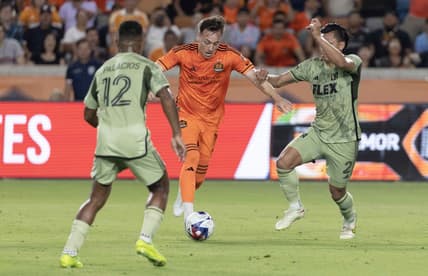 Jun 10, 2023; Houston, Texas, USA; Houston Dynamo FC forward Corey Baird (11) splits the defense of Los Angeles FC defender Diego Palacios (12) and defender Denil Maldonado (2) before scoring in the second half at Shell Energy Stadium. Mandatory Credit: Thomas Shea-USA TODAY Sports