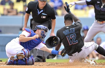 Aug 19, 2023; Los Angeles, California, USA;  Los Angeles Dodgers catcher Austin Barnes (15) tags Miami Marlins designated hitter Jorge Soler (12) out at home on a throw by Los Angeles Dodgers right fielder David Peralta (6) in the third inning at Dodger Stadium. Mandatory Credit: Jayne Kamin-Oncea-USA TODAY Sports
