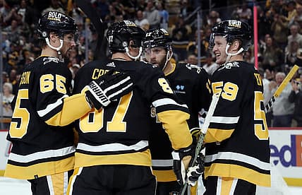 Oct 26, 2023; Pittsburgh, Pennsylvania, USA; Pittsburgh Penguins center Sidney Crosby (87) is congratulated by defenseman Erik Karlsson (65) and right wing Bryan Rust (17) and left wing Jake Guentzel (59) after scoring a goal against the Colorado Avalanche during the third period at PPG Paints Arena. The Penguins shutout the Avalanche 4-0. Mandatory Credit: Charles LeClaire-USA TODAY Sports