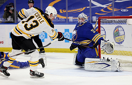 Apr 20, 2021; Buffalo, New York, USA;  Buffalo Sabres goaltender Dustin Tokarski (31) makes a pad save on Boston Bruins center Charlie Coyle (13) during the first period at KeyBank Center. Mandatory Credit: Timothy T. Ludwig-USA TODAY Sports