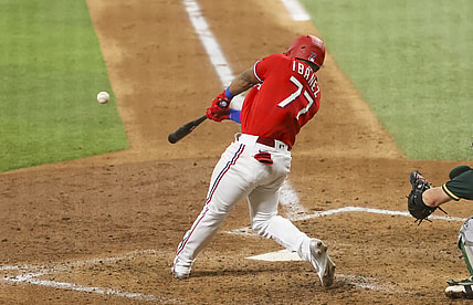 Jul 9, 2021; Arlington, Texas, USA;  Texas Rangers first baseman Andy Ibanez (77) hits an rbi single during the sixth inning against the Oakland Athletics at Globe Life Field. Mandatory Credit: Kevin Jairaj-USA TODAY Sports
