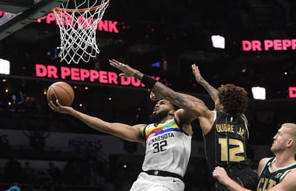 Nov 25, 2022; Charlotte, North Carolina, USA; Minnesota Timberwolves center Karl-Anthony Towns (32) drives as Charlotte Hornets forward Kelly Oubre Jr. (12) defends during the first half at the Spectrum Center. Mandatory Credit: Sam Sharpe-USA TODAY Sports