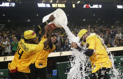 Jun 30, 2023; Pittsburgh, Pennsylvania, USA; Pittsburgh Pirates infielders Rodolfo Castro (14) and Tucupita Marcano (center) douse first baseman Carlos Santana after Santana hit a two-run walk-off home run to defeat the Milwaukee Brewers at PNC Park. Mandatory Credit: Charles LeClaire-USA TODAY Sports