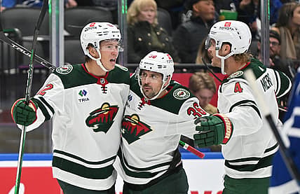 Oct 14, 2023; Toronto, Ontario, CAN;   Minnesota Wild forward Matt Boldy (12) celebrates with forward Mats Zuccarello (36) and defenseman Jon Merrill (4) after scoring a goal against the Toronto Maple Leafs in the second period at Scotiabank Arena. Mandatory Credit: Dan Hamilton-USA TODAY Sports