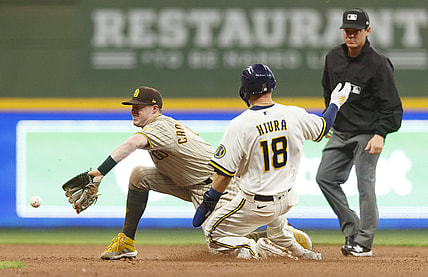 May 24, 2021; Milwaukee, Wisconsin, USA;  Milwaukee Brewers first baseman Keston Hiura (18) takes second base on a wild pitch as San Diego Padres second baseman Jake Cronenworth (9) takes the throw during the fourth inning at American Family Field. Mandatory Credit: Jeff Hanisch-USA TODAY Sports