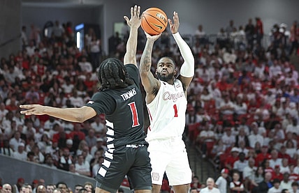 Feb 27, 2024; Houston, Texas, USA; Houston Cougars guard Jamal Shead (1) shoots the ball as Cincinnati Bearcats guard Day Day Thomas (1) defends during the first half at Fertitta Center. Mandatory Credit: Troy Taormina-USA TODAY Sports