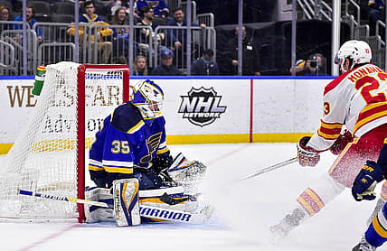 Jan 27, 2022; St. Louis, Missouri, USA;  St. Louis Blues goaltender Ville Husso (35) defends the net against Calgary Flames center Sean Monahan (23) during the first period at Enterprise Center. Mandatory Credit: Jeff Curry-USA TODAY Sports