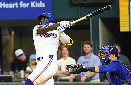 Mar 30, 2024; Arlington, Texas, USA;  Texas Rangers right fielder Adolis Garcia (53) hits a sacrifice fly rbi during the eighth inning against the Chicago Cubs at Globe Life Field. Mandatory Credit: Kevin Jairaj-USA TODAY Sports