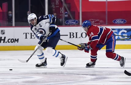 Apr 30, 2021; Montreal, Quebec, CAN; Winnipeg Jets forward Blake Wheeler (26) skates with the puck and Montreal Canadiens forward Nick Suzuki (14) defends during the first period at the Bell Centre. Mandatory Credit: Eric Bolte-USA TODAY Sports