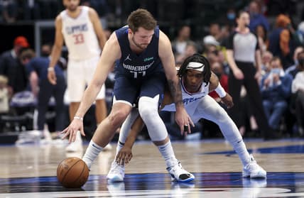 Feb 10, 2022; Dallas, Texas, USA;  Dallas Mavericks guard Luka Doncic (77) dribbles as LA Clippers guard Terance Mann (14) defends during the second quarter at American Airlines Center. Mandatory Credit: Kevin Jairaj-USA TODAY Sports